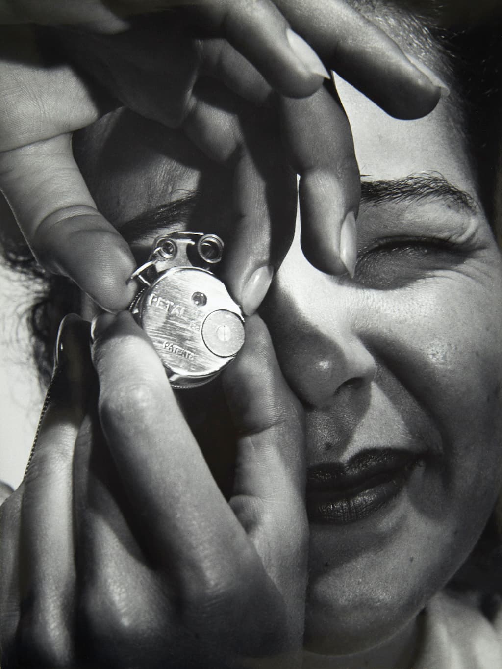 Woman holding miniature camera, 1949